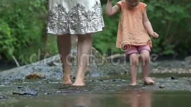 母亲和小女儿光着脚在岩石上划桨
